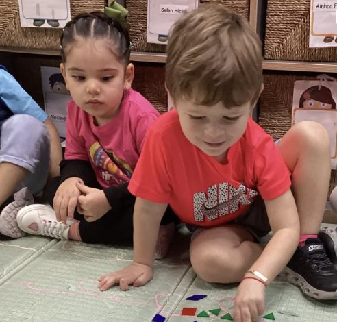 Niño concentrado armando figuras con bloques geométricos