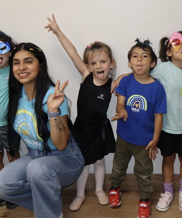Maestra con niños de Tiniciti, una niña con mallas y zapatillas de ballet