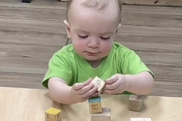 Bebé jugando con bloques de madera con letras