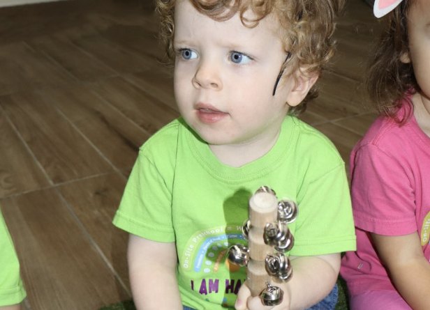 Niño tocando cascabeles en la clase de música